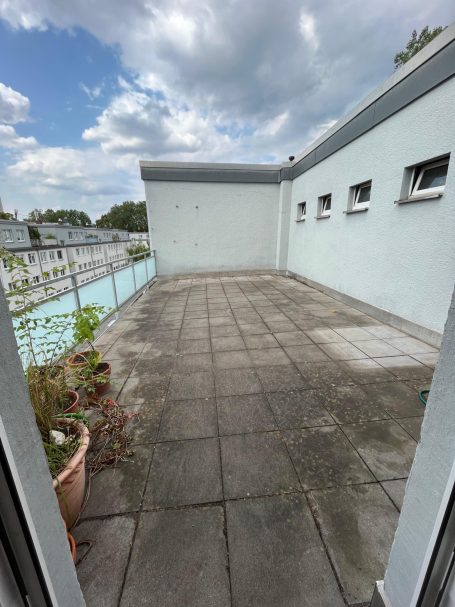 Handwerker verlegt WPC-Fliesen zur Gestaltung einer Dachterrasse.