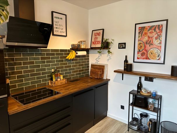 Küchenzeile mit Regalen & Dunstabzugshaube Montierte Küchenzeile mit Wandregalen und installierter Dunstabzugshaube.