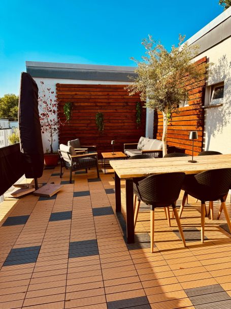 Dachterrasse mit WPC-Fliesen & Akustik-Dielen Verlegte WPC-Fliesen auf einer Dachterrasse sowie mit Akustik-Dielen verkleidete Wände.