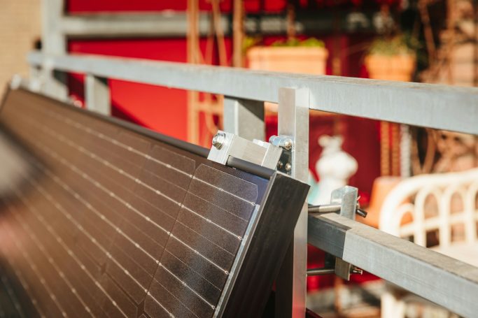 Am Balkongeländer befestigtes Balkonkraftwerk mit Solarmodul.